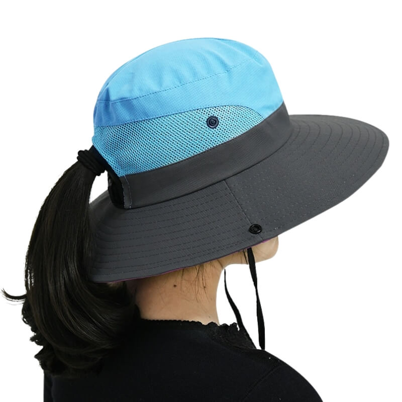 Femme de dos portant un chapeau de soleil bleu SunShade avec ouverture pour queue de cheval.
