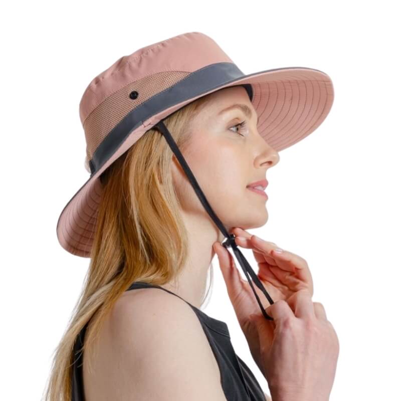 Femme ajustant le cordon de son chapeau de soleil SunShade rose et gris.