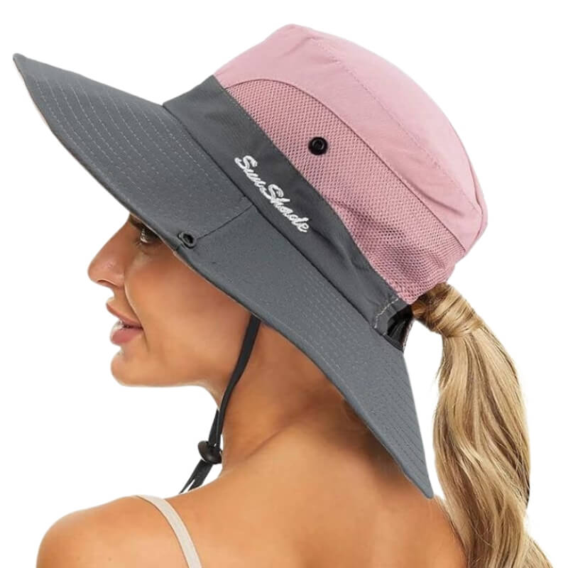 Femme souriante vue de profil portant un chapeau SunShade rose et gris avec maille filet.