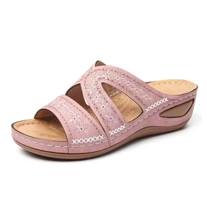 Sandale rose pour femme, design ajouré et couture contrastée, présentée sur fond blanc.