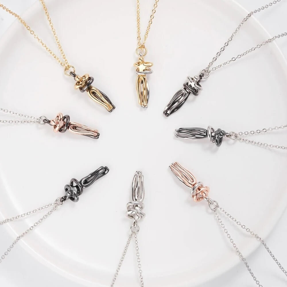 Colliers couple étreinte en forme de cercle disposés en étoile sur une assiette blanche – Bijoux symboliques multicolores