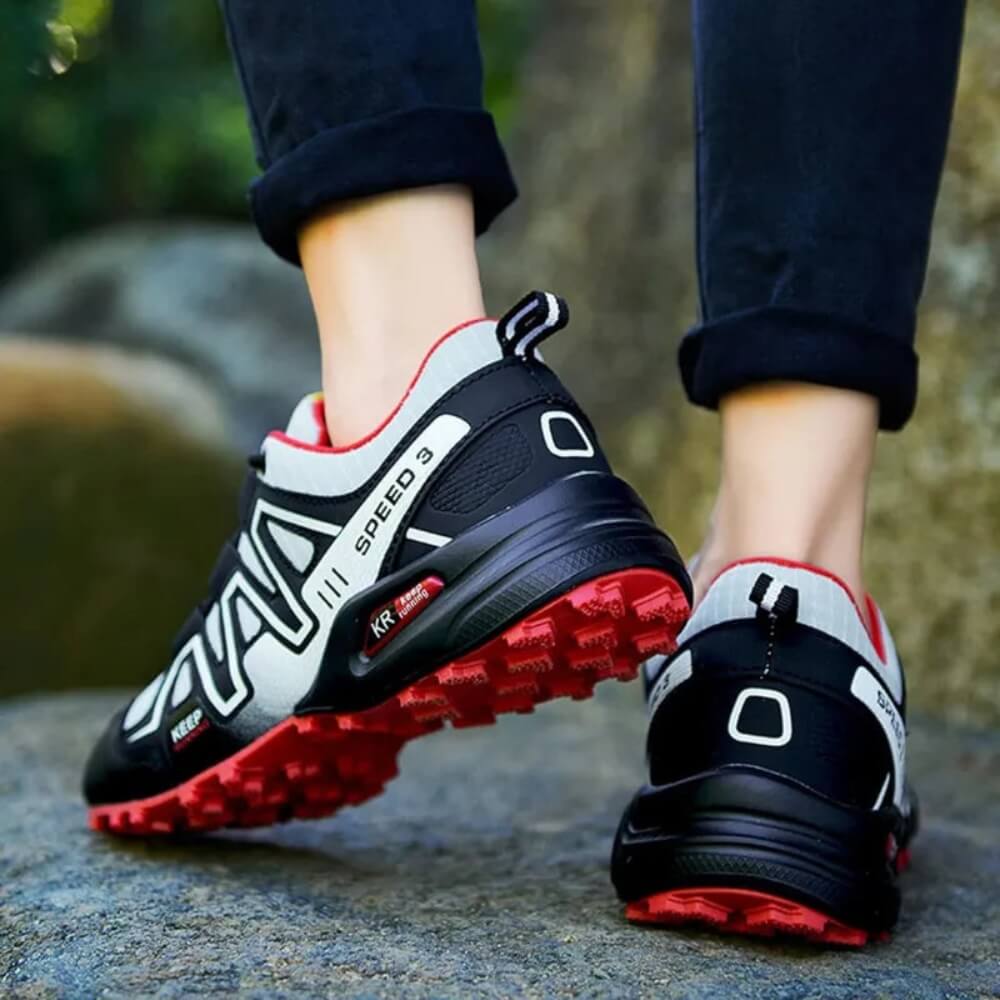 Vue arrière des chaussures Monreux OrthoTrek noires et rouges, semelle antidérapante pour trekking.
